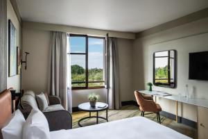 a hotel room with a bed and a living room at Crowne Plaza Paris Marne-la-Vallée in Magny-le-Hongre
