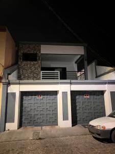 a house with two garage doors with a car parked in front at Modern House with Private Pool in Santa Rosa de Copán