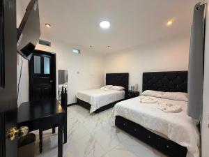 a bedroom with two beds and a piano at Hotel Gods Blessing in Nebaj