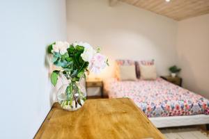 a vase of flowers on a table in a bedroom at Chambre d'hôtes Château Austerlitz in Libourne