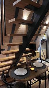 a dining room with a table with plates on it at Breeze Cabin كوخ النسيم in Ilijaš