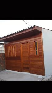 a wooden garage with two doors on a house at Kitnet Completa Próx Unipampa e Centro Wi-Fi in Alegrete