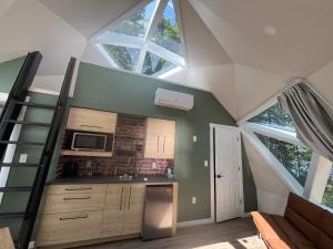 a kitchen with a vaulted ceiling with skylights at Blue Bayou Dome cottages in Dingwall