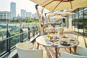 a restaurant with tables and chairs with food on a balcony at InterContinental Yokohama Pier 8 by IHG in Yokohama