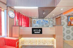 a waiting room with a red couch and a sign at Super Hotel O Kanode Gate Formerly Hotel Dhruv in Rewāri