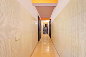 an empty hallway with white tile walls and a long corridor at Super Hotel O Kanode Gate Formerly Hotel Dhruv in Rewāri