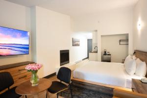 a bedroom with a white bed and a fireplace at Sunshine Lodge Inn in Gibsons