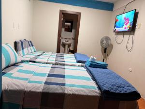 a bedroom with a bed and a flat screen tv at Hostal Muchik in Chiclayo +1 photo