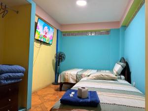 a room with a bed and a tv on a wall at Hostal Muchik in Chiclayo