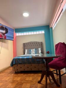 a bedroom with a bed with a table and a mirror at Hostal Muchik in Chiclayo