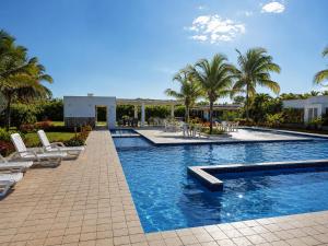 a swimming pool with lounge chairs and palm trees at Blue Diamond Suite de playa in Playa Blanca