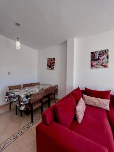 a living room with a red couch and a table at Luxueuse à Marina Saidia in Saïdia