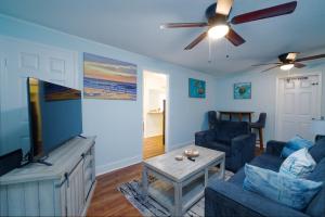 a living room with a couch and a flat screen tv at Dolphin Retreat in Brunswick