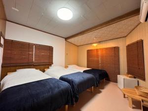 two beds in a room with two windows at Calmbase西伊豆いざよい in Numazu