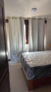 a bed in a room with white curtains at Hotel GUERRERO in Zacatlán