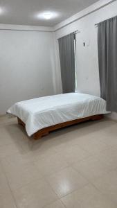 a large bed in a room with a window at Hotel GUERRERO in Zacatlán