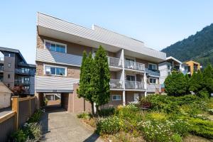 an apartment building with a garden in front of it at Harrison Lake Retreat, Studio Suite in Harrison Hot Springs