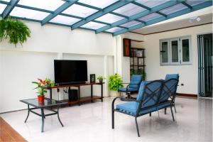 a living room with two chairs and a television at Mi Barrio in Cartago