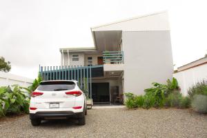 a white car parked in front of a house at Mi Barrio in Cartago