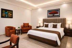 a hotel room with a bed and a chair at Elite Gold Luxury Hotel in Abuja +18 photos