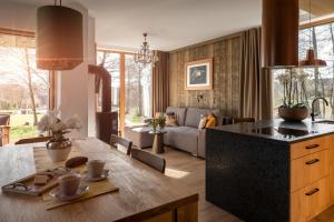 a kitchen and living room with a wooden table at CHATY U HARREGO NAD STAWEM SPA sauna, balia, rowery, klimatyzacja, in Kudowa-Zdrój