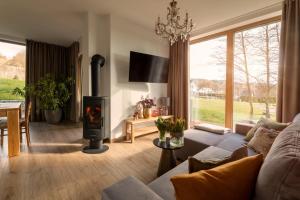a living room with a couch and a fire place at CHATY U HARREGO NAD STAWEM SPA sauna, balia, rowery, klimatyzacja, in Kudowa-Zdrój