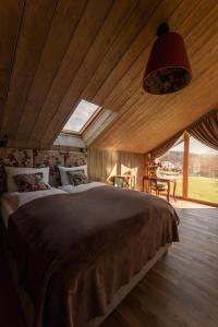 a bedroom with a large bed and a large window at CHATY U HARREGO NAD STAWEM SPA sauna, balia, rowery, klimatyzacja, in Kudowa-Zdrój