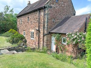 an old brick house with a garden in front of it at Ye Olde Stone House in Sutton Coldfield