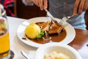 a person eating a plate of food on a table at Landal Arber in Zwiesel