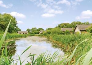 a river in a field with houses and grass at Oakwood Lodges in Skipwith