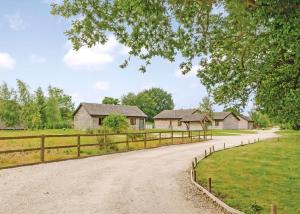 a house with a fence and a dirt road at Oakwood Lodges in Skipwith