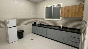 a kitchen with a sink and a refrigerator at شقة واسعة وانيقة in Hail