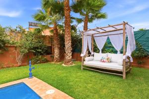 a swing in a yard next to a pool at Villa des Roses in Marrakesh