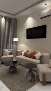 a living room with two couches and a table at شقة واسعة وانيقة in Hail