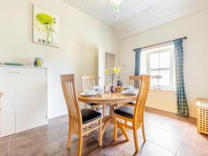 a dining room with a wooden table and chairs at Allt Bronach - Ukc5763 in Laggan
