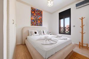 a white bedroom with a large bed with white sheets at Villa des Roses in Marrakesh +32 photos