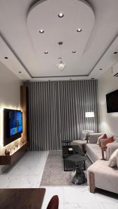 a living room with a couch and a tv at شقة واسعة وانيقة in Hail +4 photos