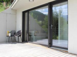 a sliding glass door of a house with a table at Modern apartment in the Tyrolean mountains in Fliess