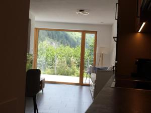 a living room with a large sliding glass door with a view at Modern apartment in the Tyrolean mountains in Fliess