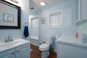 a bathroom with a white toilet and a sink at Dolphin Retreat in Brunswick