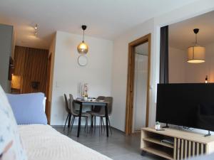 a bedroom with a bed and a table with a television at Modern apartment in the Tyrolean mountains in Fliess
