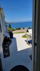 a view of the ocean from a house with chairs at Oceanfront Classic Maine Cottage In Close Walking Distance To Beaches! in York