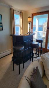 a living room with a bar with stools and a couch at Oceanfront Classic Maine Cottage In Close Walking Distance To Beaches! in York +14 photos