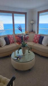 a living room with a couch and a table with flowers at Oceanfront Classic Maine Cottage In Close Walking Distance To Beaches! in York