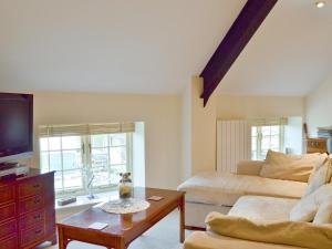 a living room with a couch and a tv at Highfield Barn in Coulton