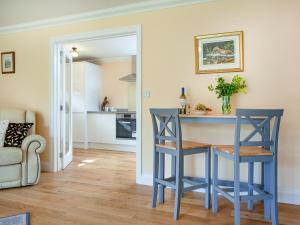 a kitchen with a blue table and two chairs at 1 The Folly's - Uk45189 in Abbotskerswell