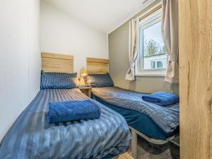 two beds in a room with a window at No29 - Uk52060 in Hartland +6 photos