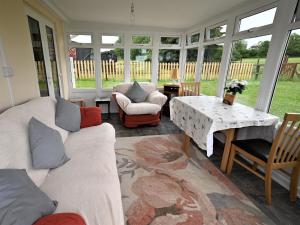 a living room with couches and a table and windows at Orchard Farm Cottage in Barnby +10 photos