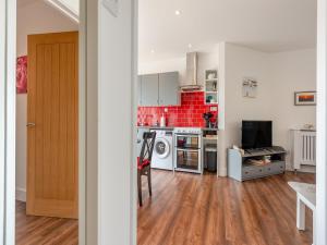 a kitchen with red tiles on the wall at The Laurels in Goodwick +18 photos