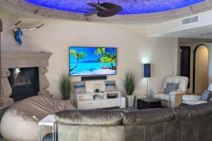 a living room with a couch and a tv on the wall at Bella Sirena Villa 8 - Your Dream Coastal Escape in Puerto Peñasco